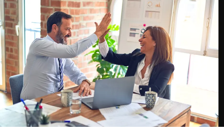 Colleagues doing a high five after a successful work day